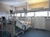 Leito de unidade de terapia intensiva cercado por equipamentos médicos modernos em um ambiente hospitalar.