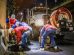 Trabalhadores fazem a limpeza de um sistema de drenagem urbana à noite, sob um viaduto, utilizando equipamentos e maquinaria.