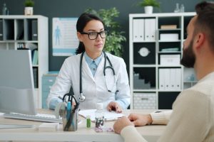 Médico conversa com paciente durante consulta em uma clínica.
