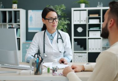 Médico conversa com paciente durante consulta em uma clínica.