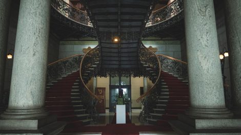 Escadaria ornamentada no interior de um edifício governamental histórico de Belo Horizonte.