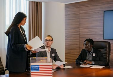 Grupo de profissionais reunido em uma sala de conferências para discutir planos eleitorais.