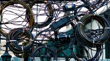Emaranhado de cabos de energia e telecomunicações instalado ao ar livre.