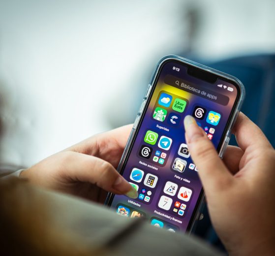 Mulher segura um smartphone que exibe diversos aplicativos.
