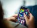 Mulher segura um smartphone que exibe diversos aplicativos.